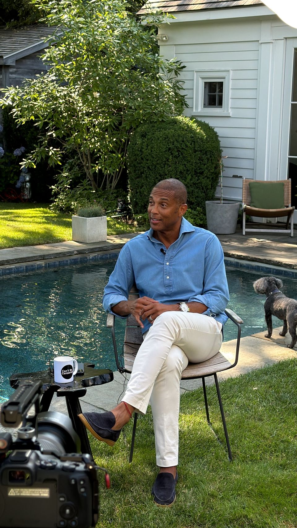 Guest seated in a garden beside a swimming pool
